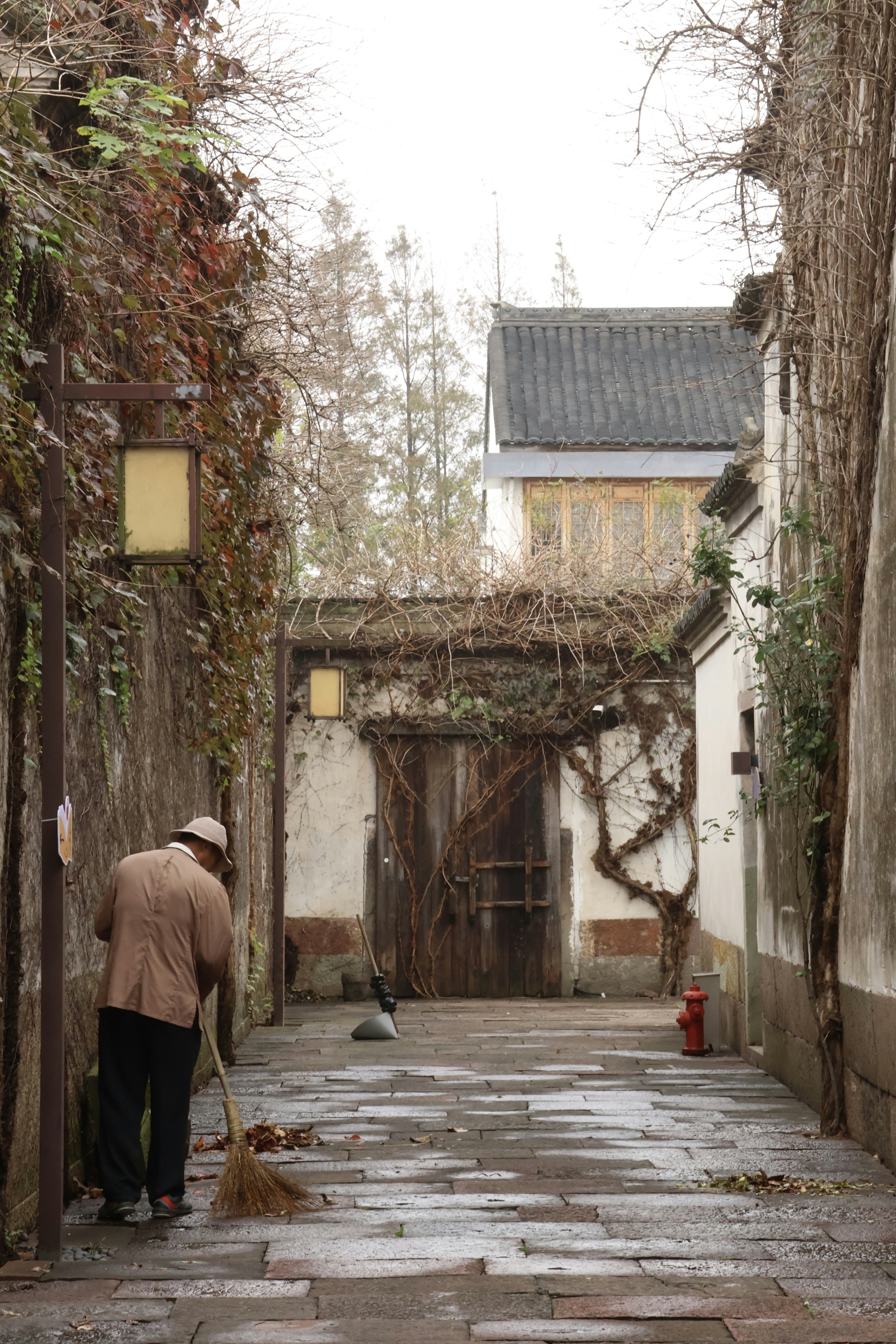 A person with a broom is sweeping the street