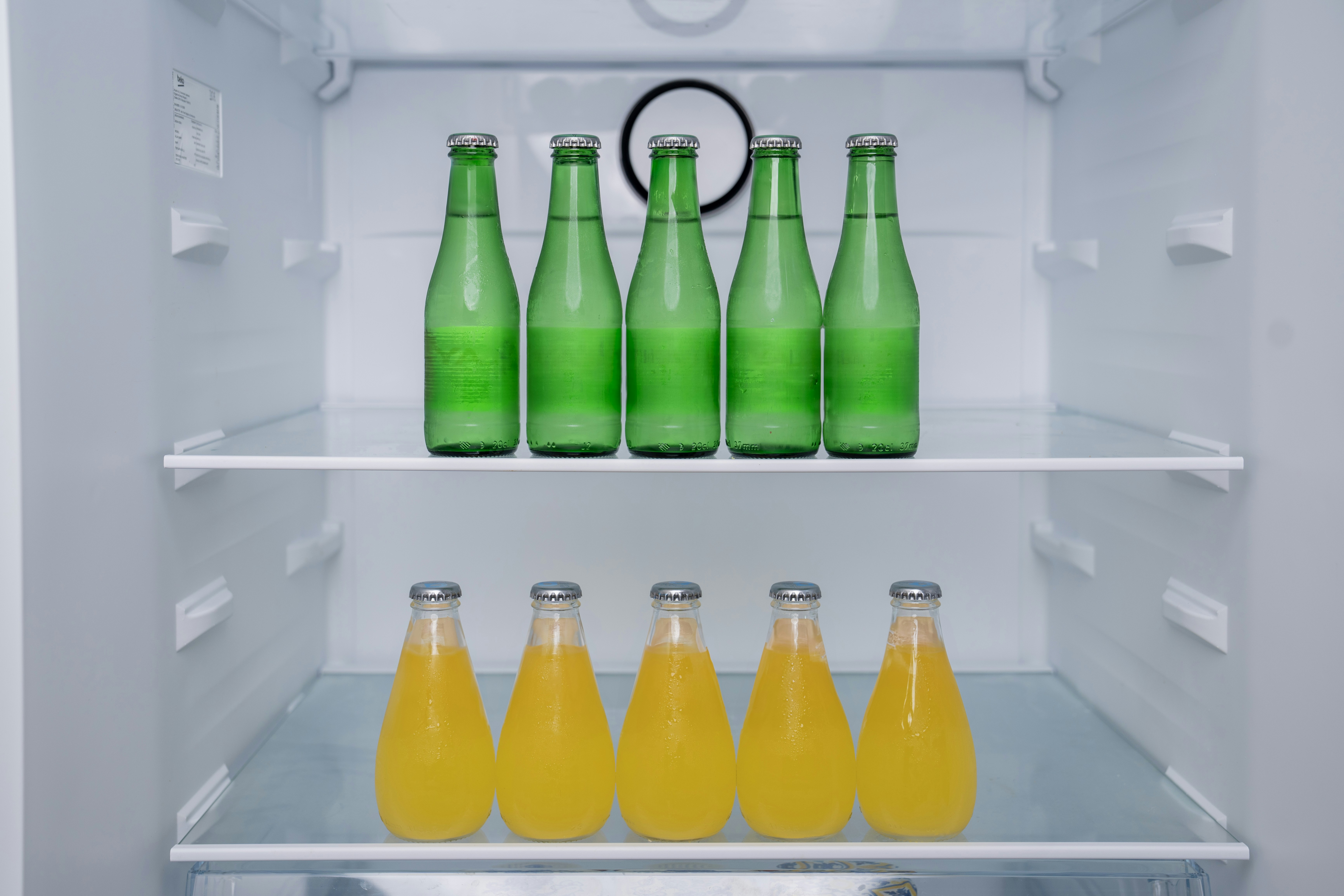 冷蔵庫のなかに瓶に入った飲み物が並ぶ様子