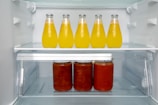 A refrigerator filled with lots of bottles of juice