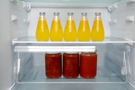 A refrigerator filled with lots of bottles of juice