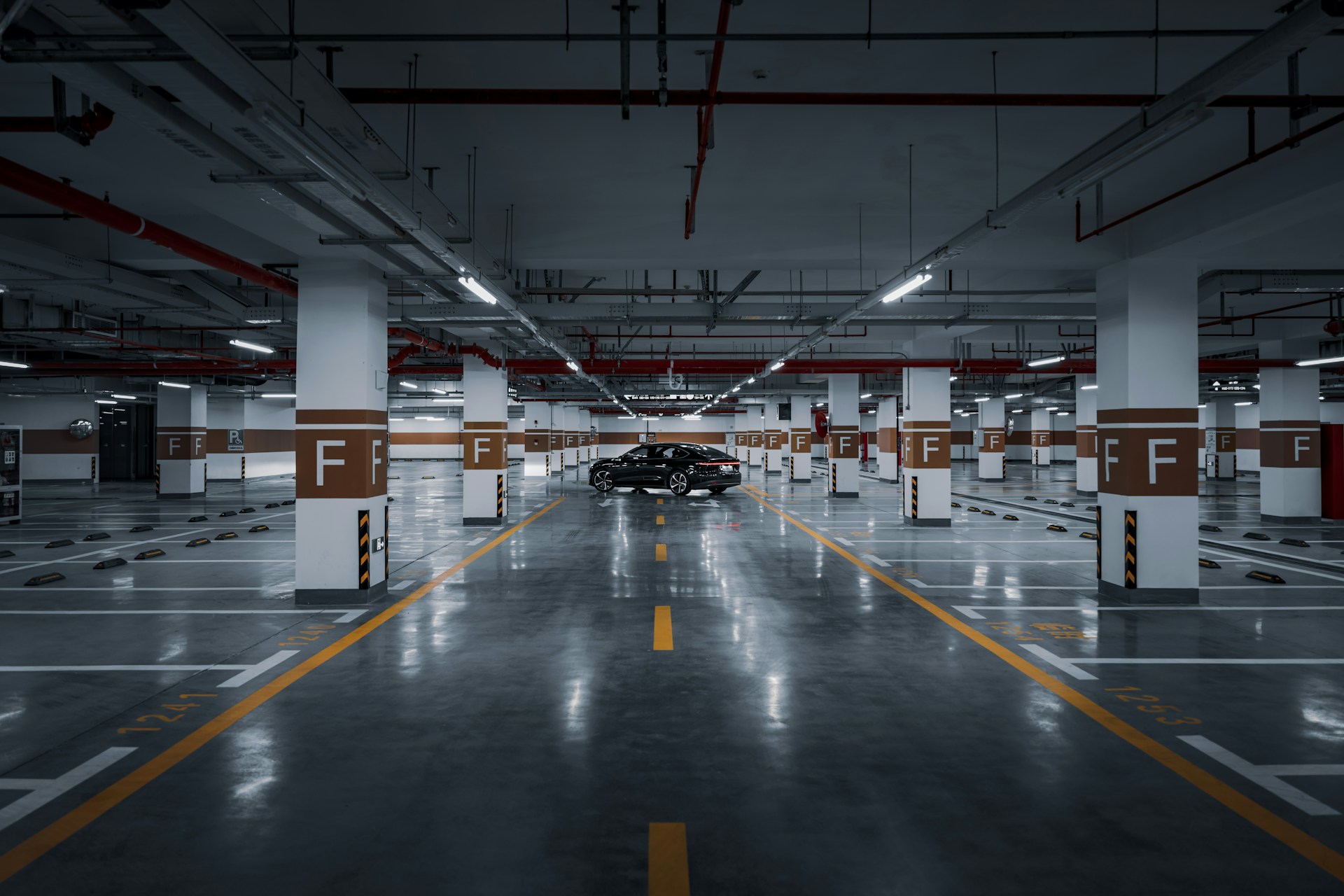 An empty parking garage with a car parked in it