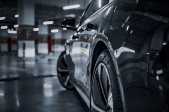 A black and white photo of a car in a parking garage