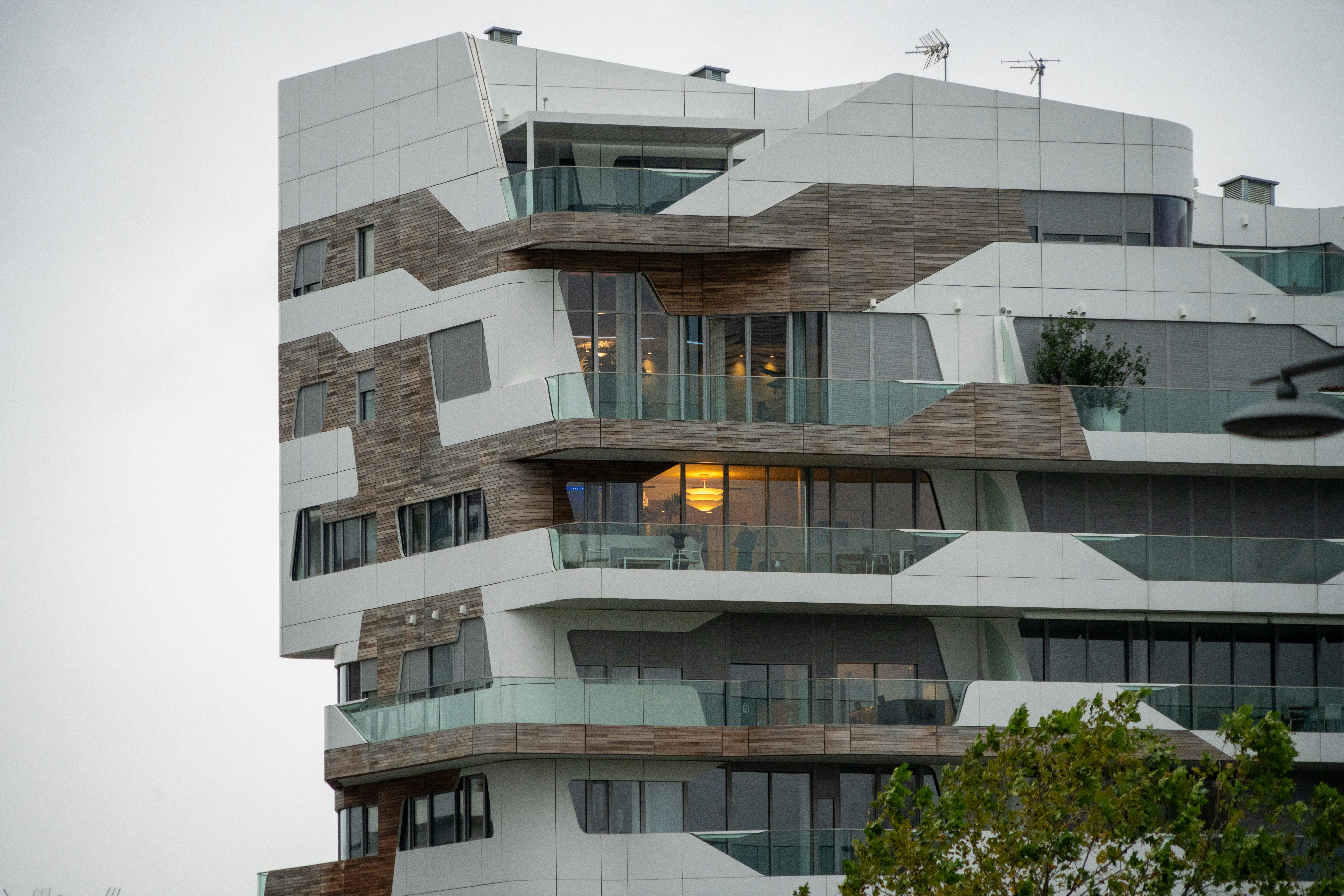 A tall white building with balconies and balconies