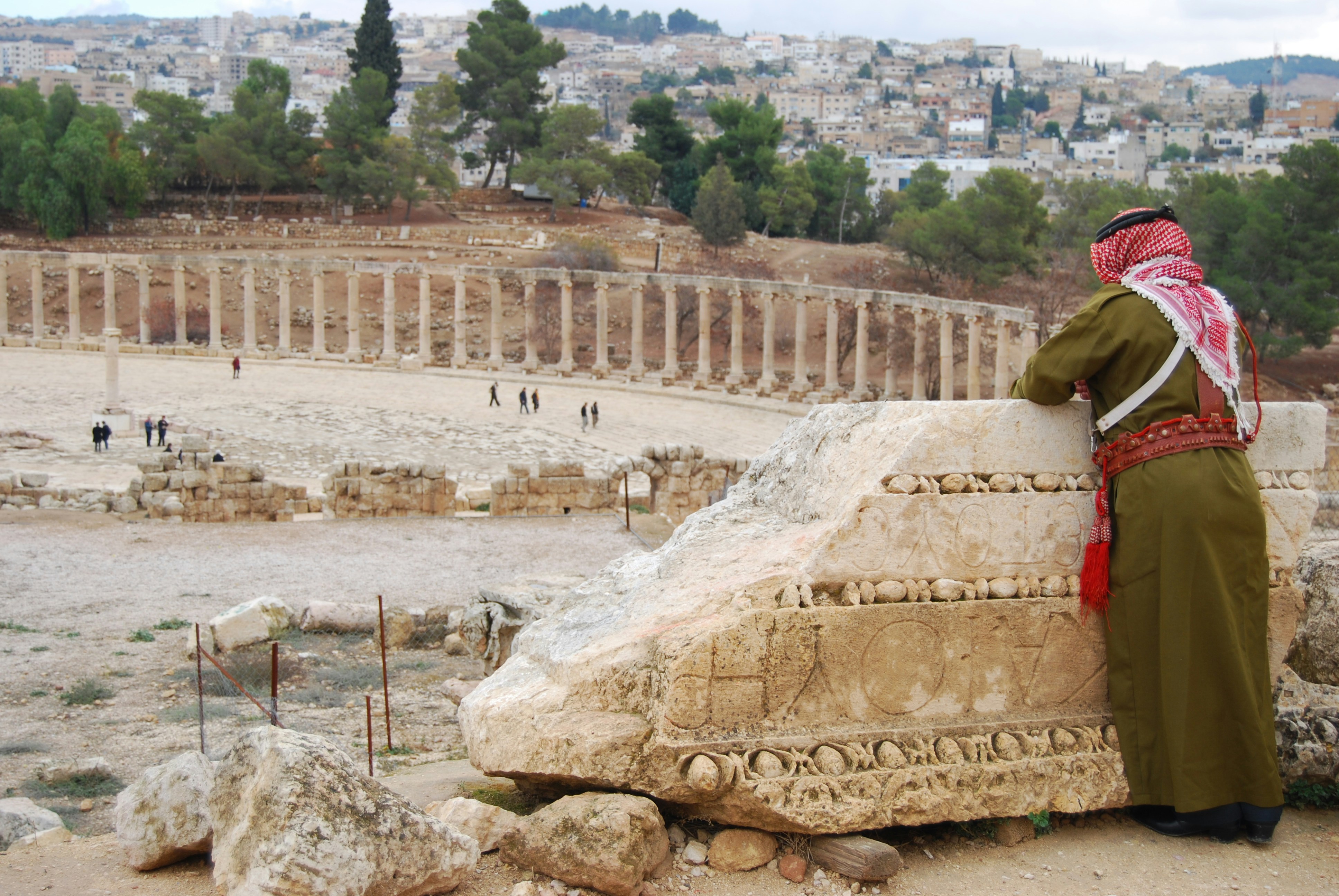 A man standing next to a large rock