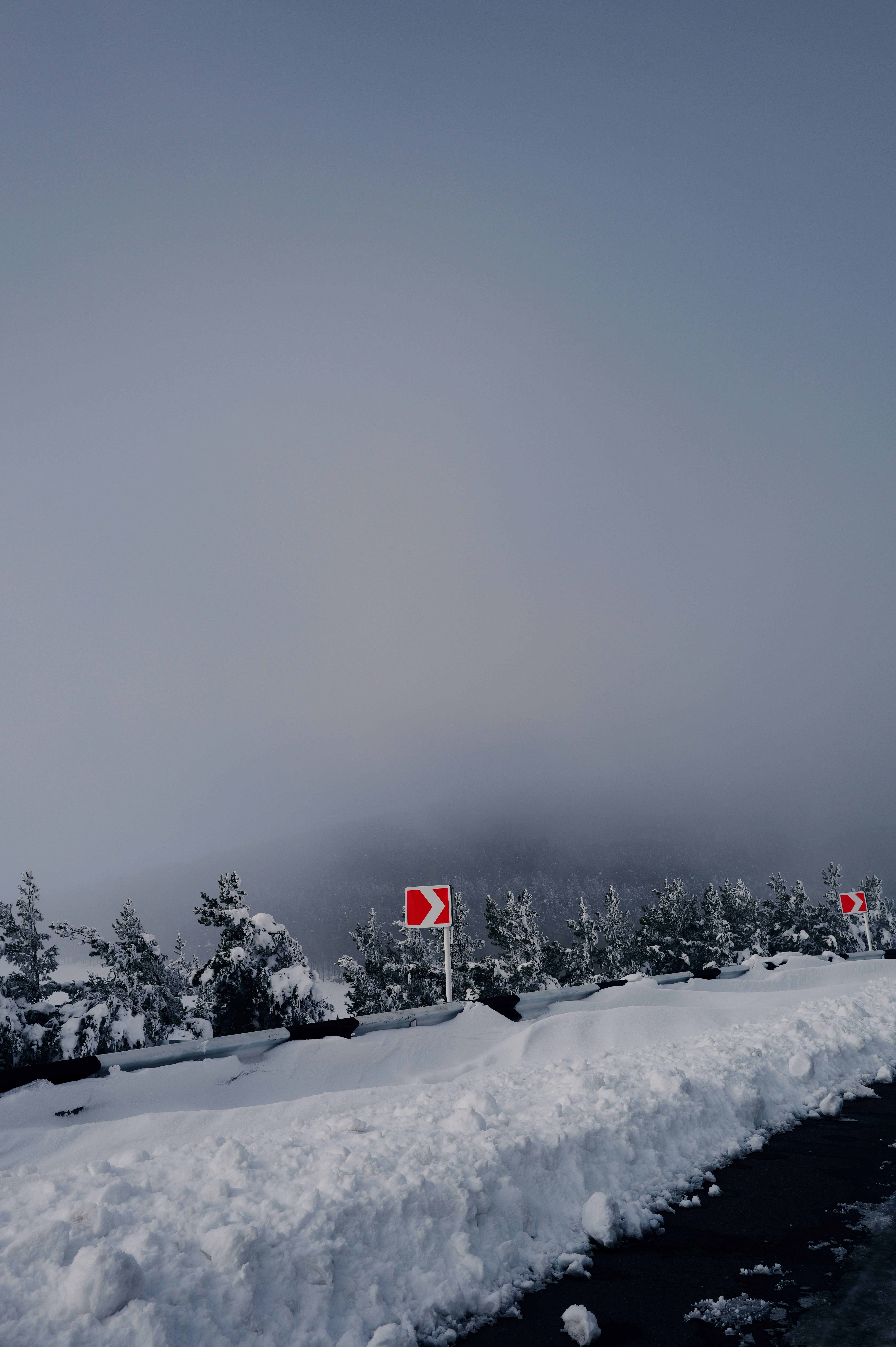 A snow covered road with a red stop sign