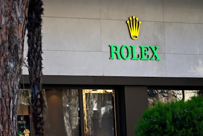 A rolex store with a palm tree in front of it
