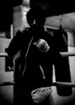 A man standing in a boxing ring wearing a hoodie