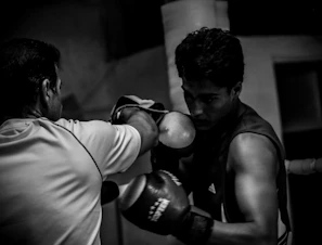 A black and white photo of two men boxing