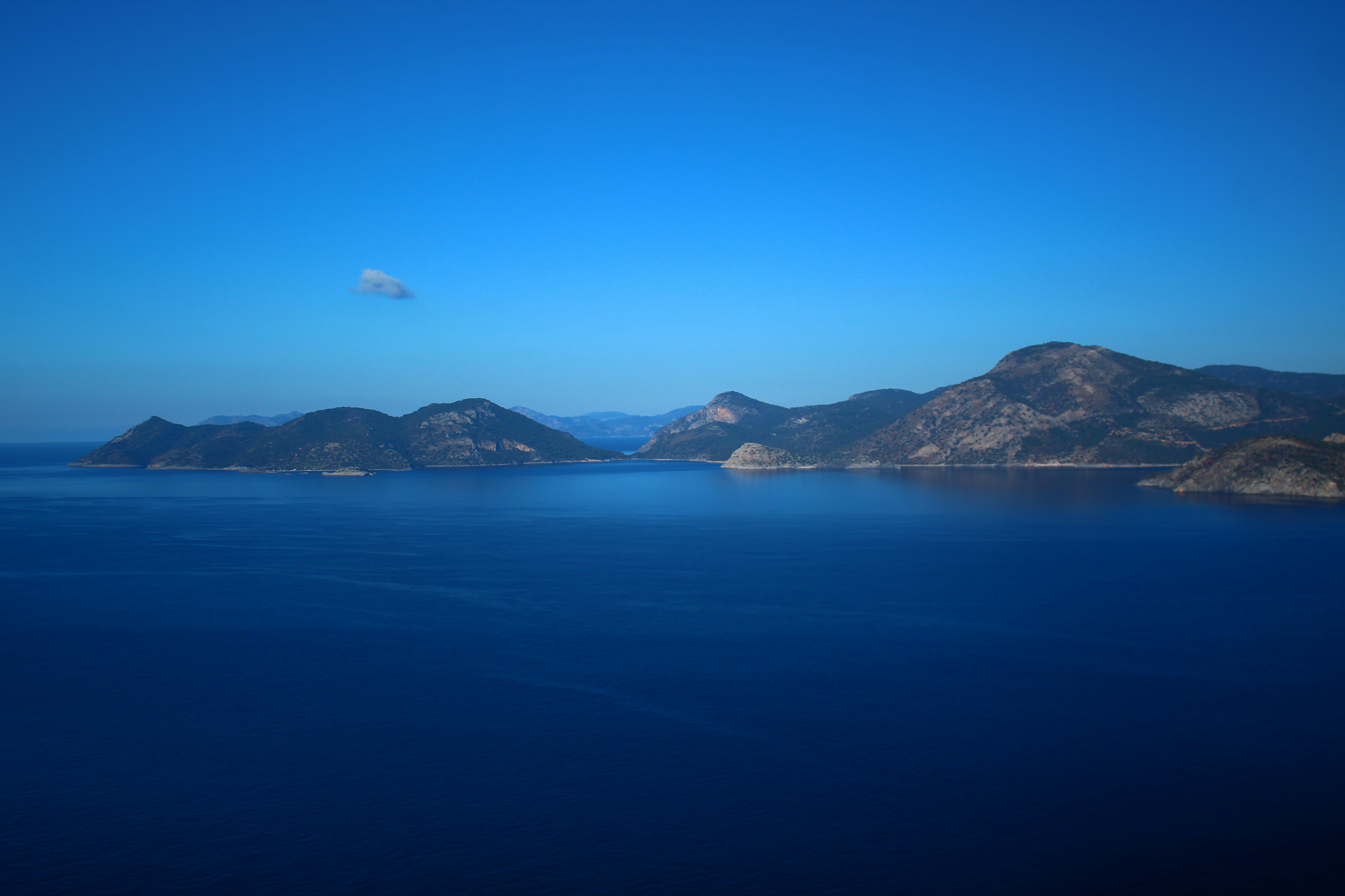 A body of water with mountains in the background