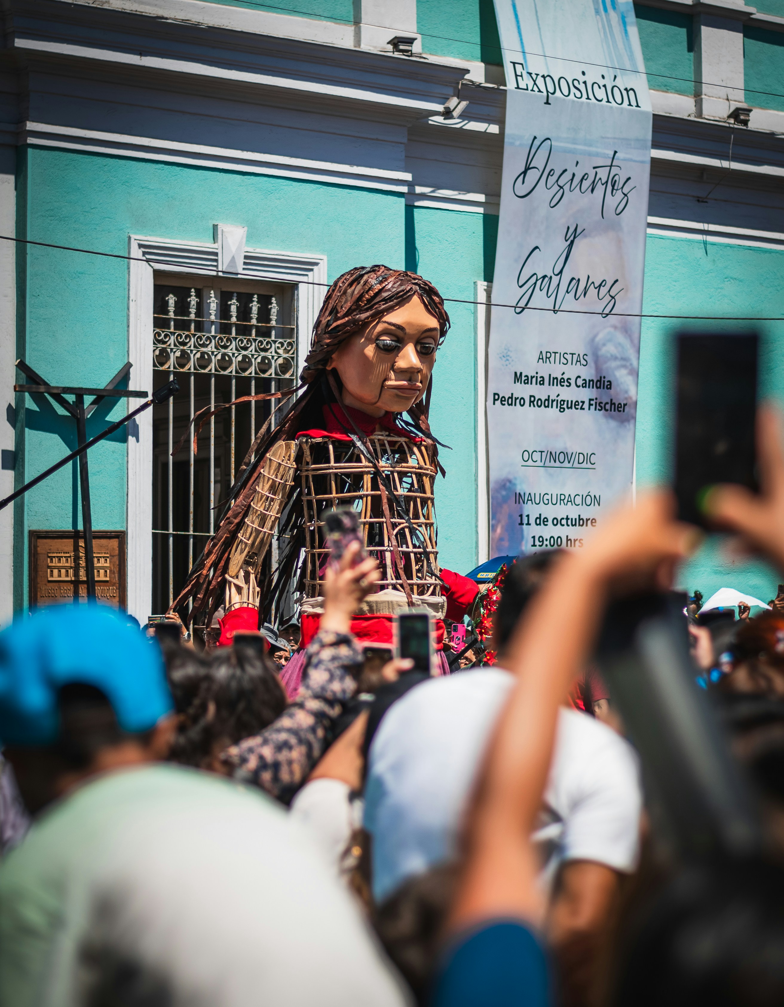 A woman with dreadlocks walking in front of a crowd of people