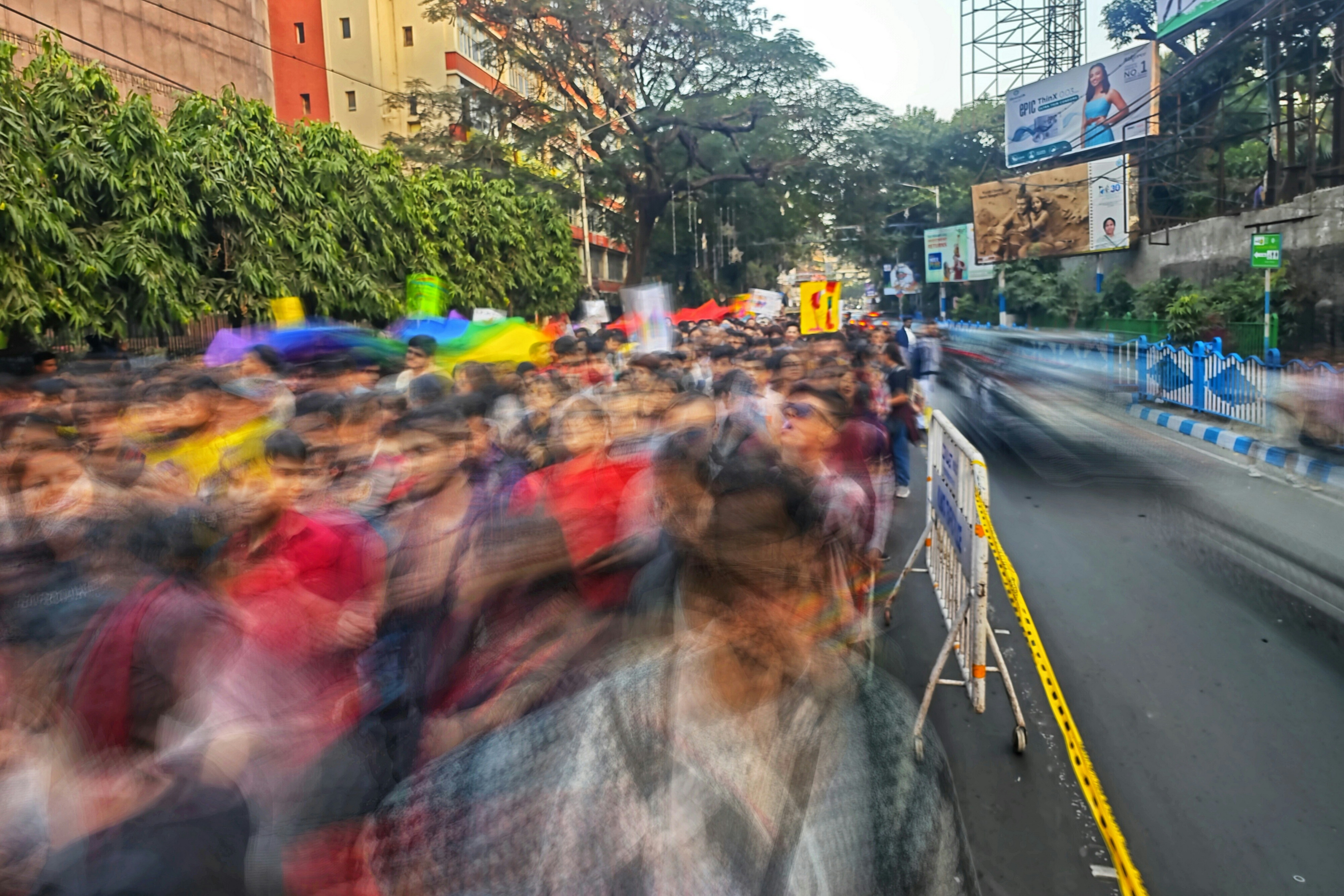 A crowd of people walking down a street next to tall buildings