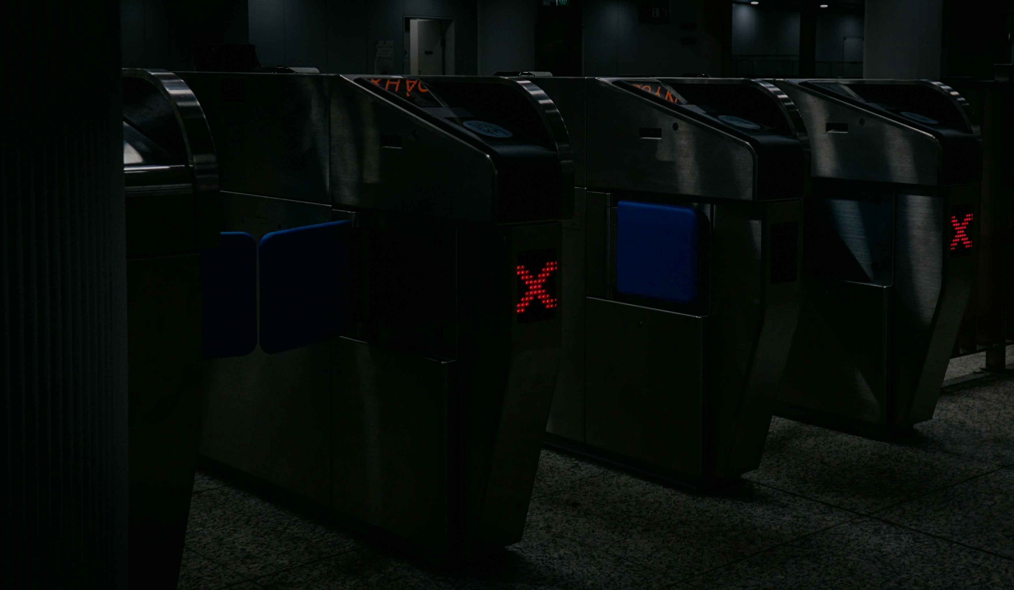 A row of black trash cans in a dark room