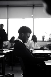 A man sitting at a desk using a laptop computer