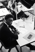 A black and white photo of a man sitting at a desk