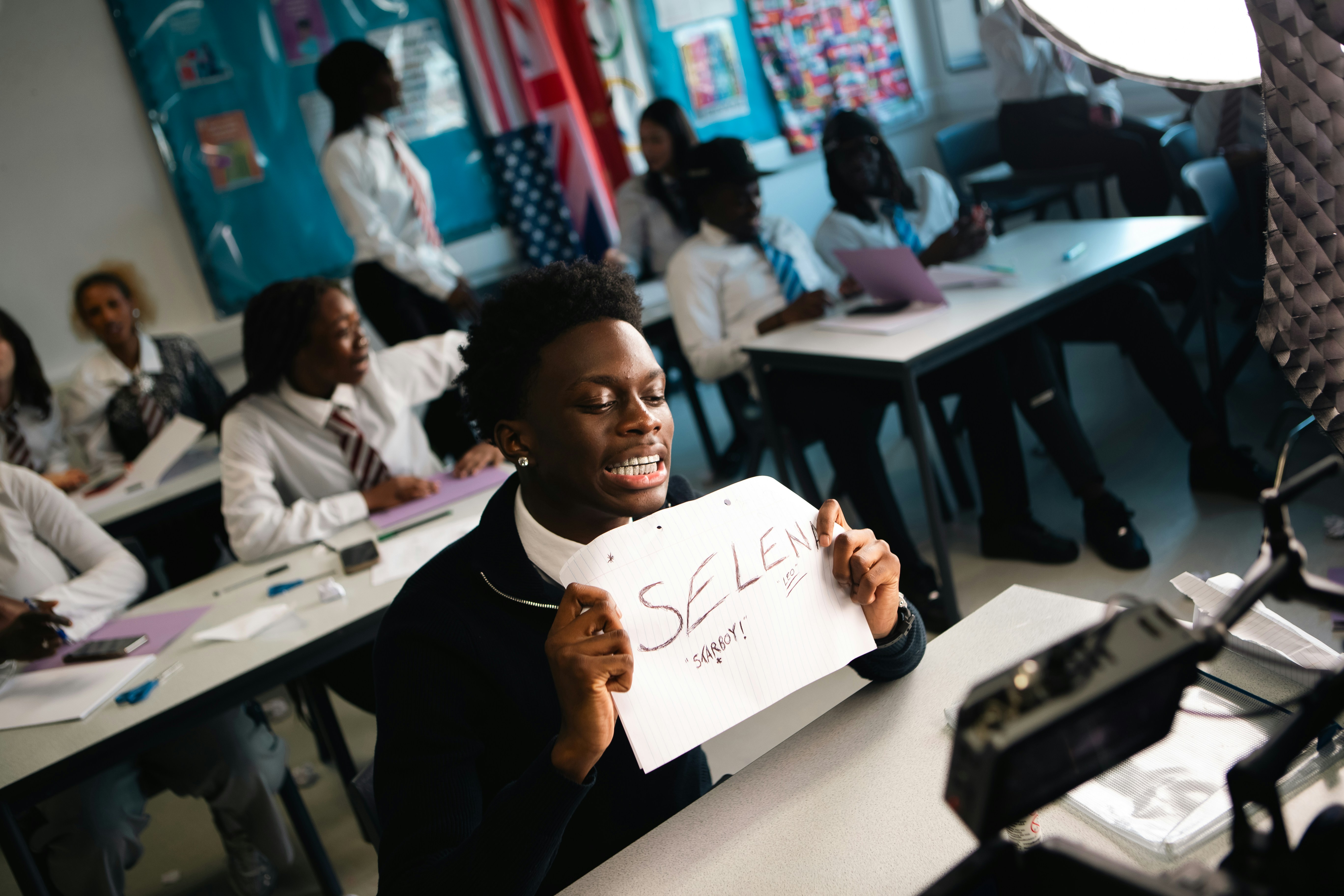 A woman holding a sign in a classroom