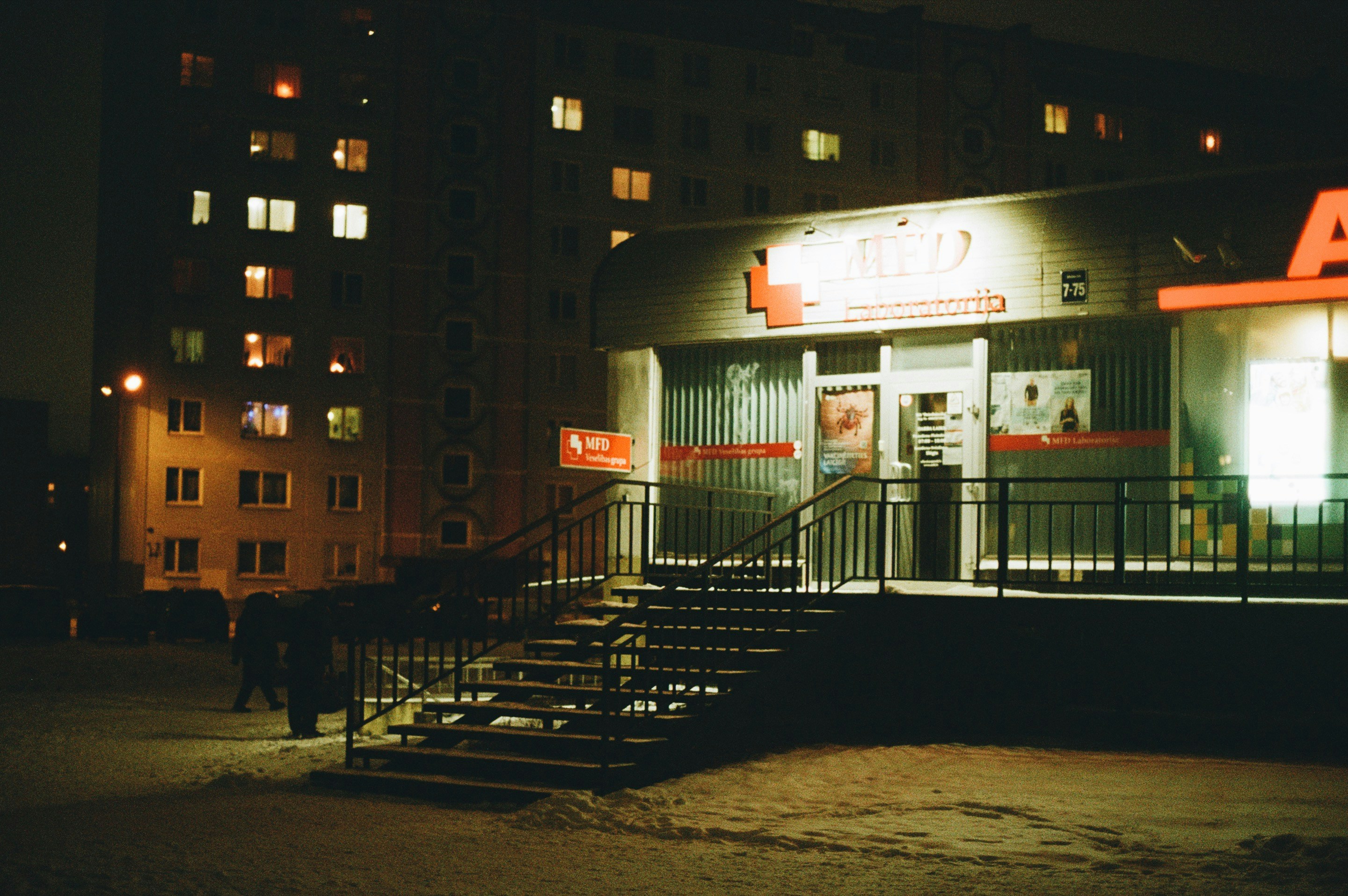 A building lit up at night with stairs leading up to it