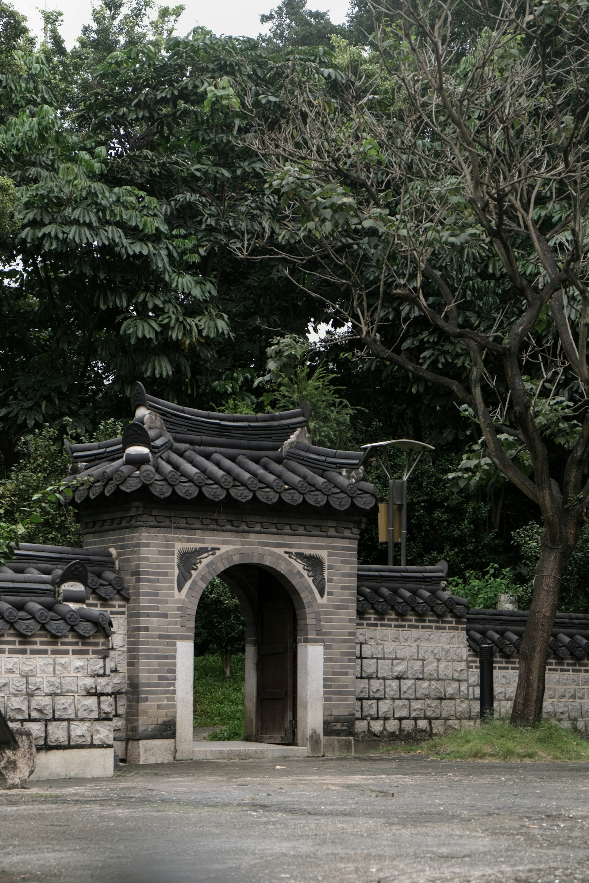 A gate in a stone wall with trees in the background