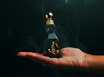 A person holding a small bottle with an anchor on it