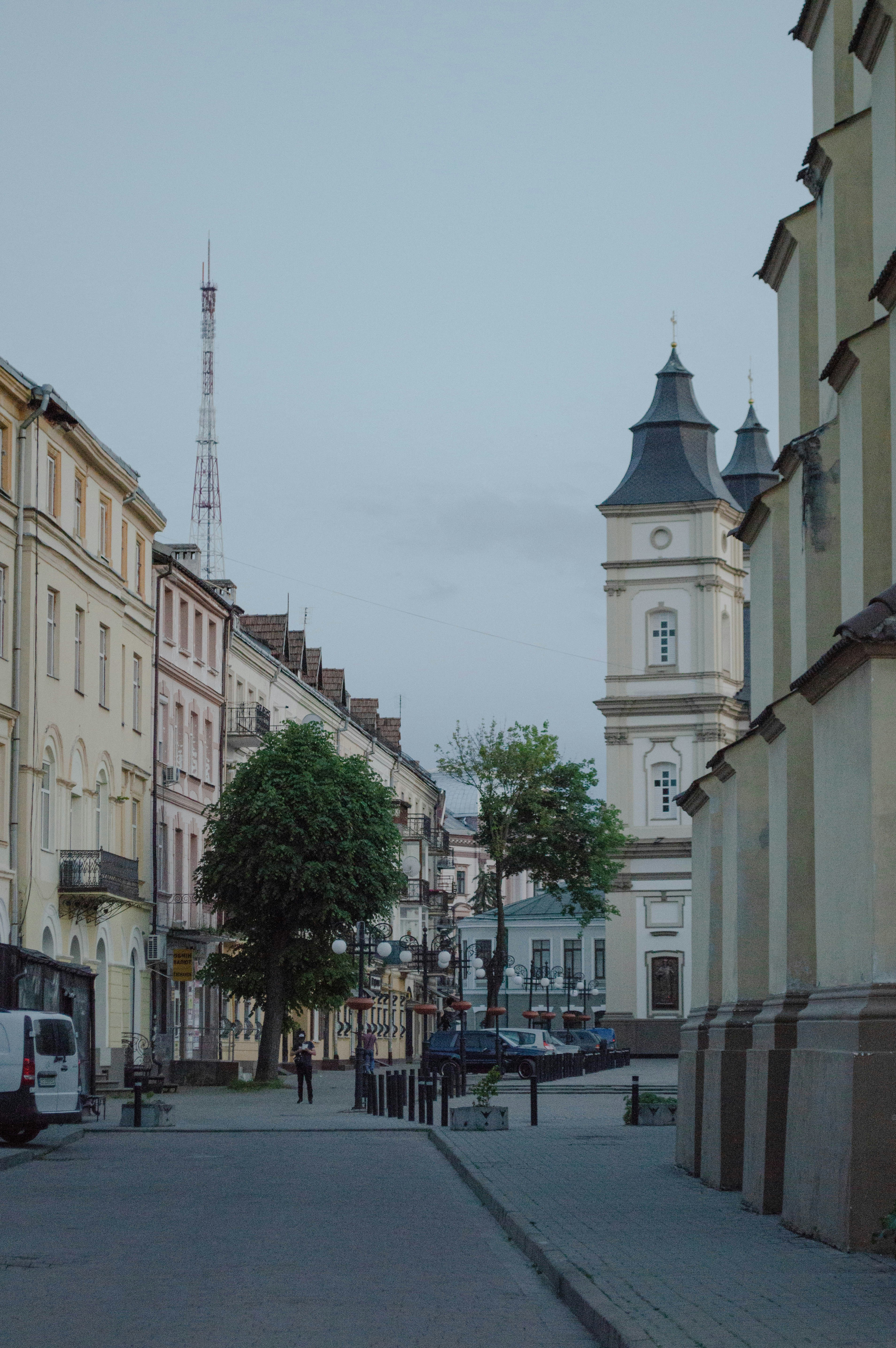 A city street lined with tall buildings and a clock tower