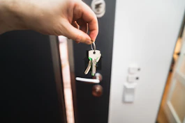 A person is holding a key to a door