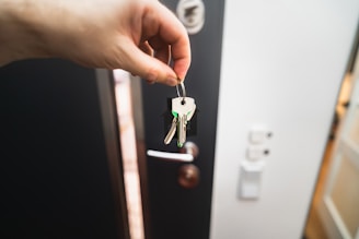 A person is holding a key to a door