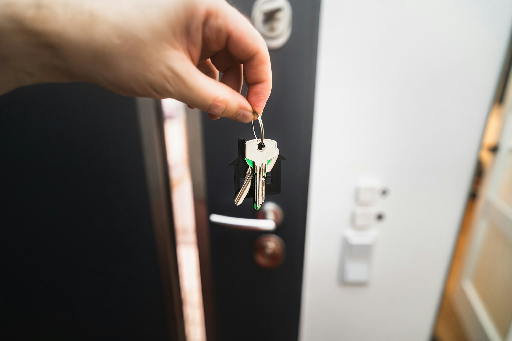 A person is holding a key to a door