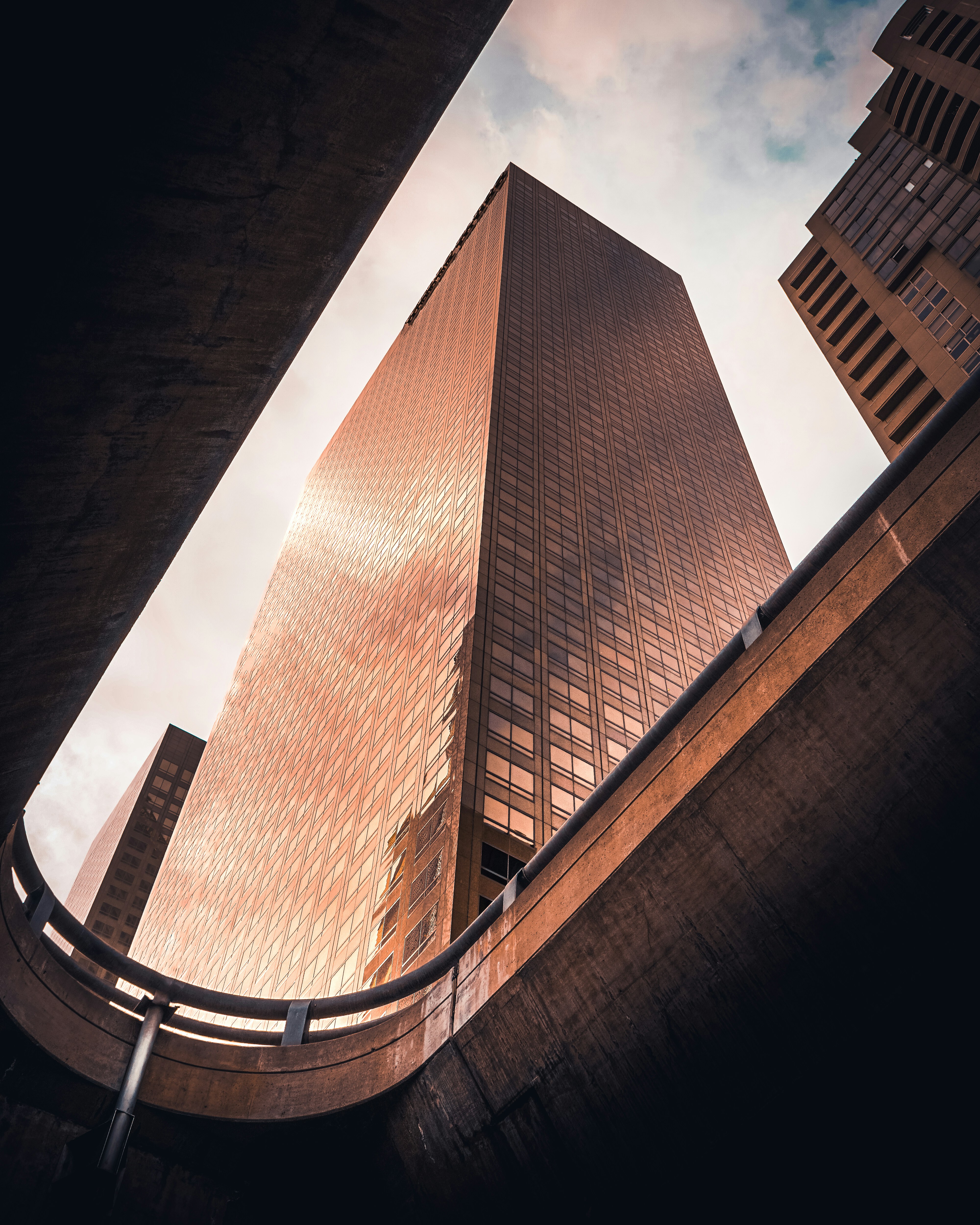 A tall building towering over a city under a cloudy sky