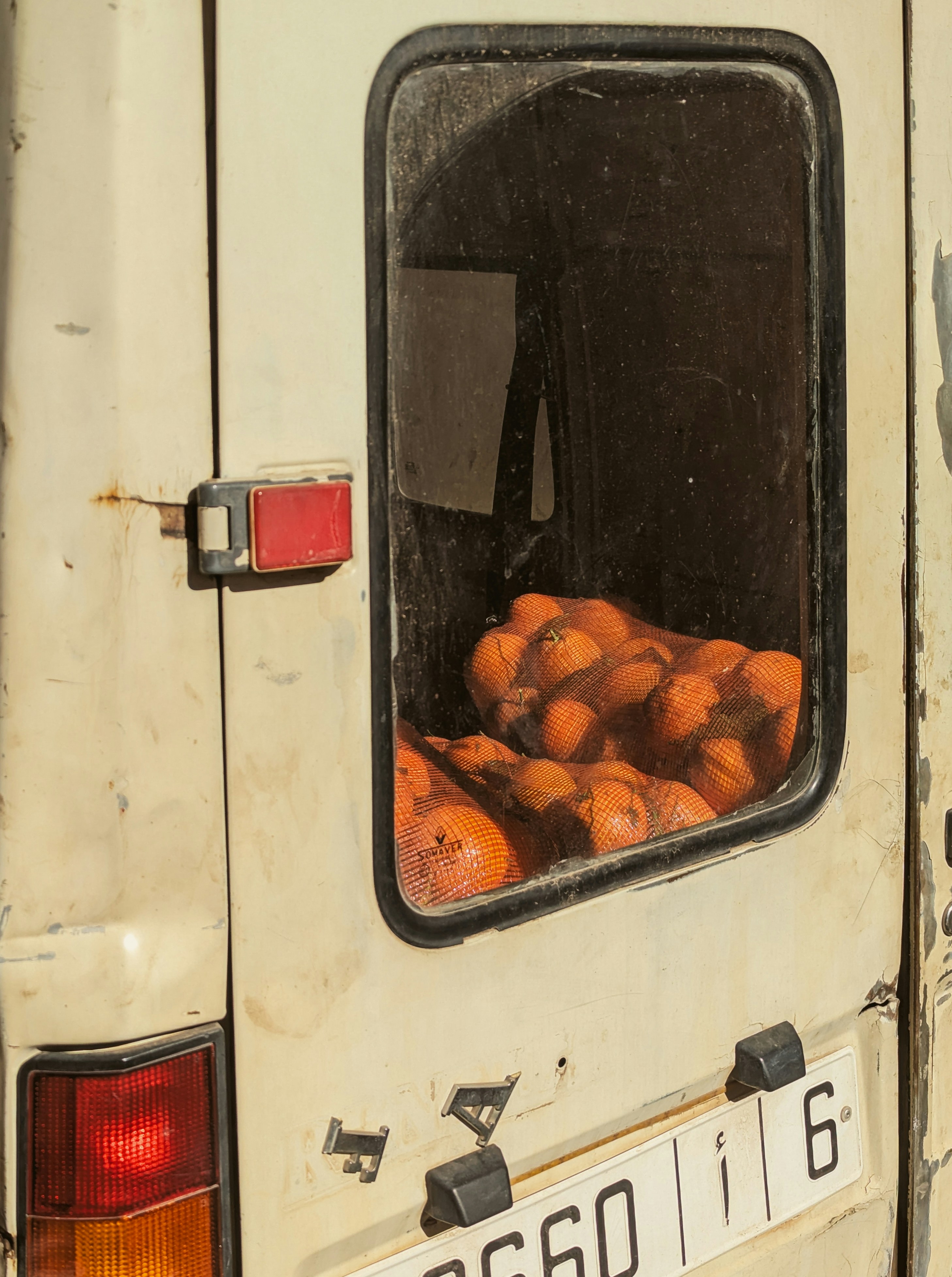 A truck with a bunch of oranges in the back window