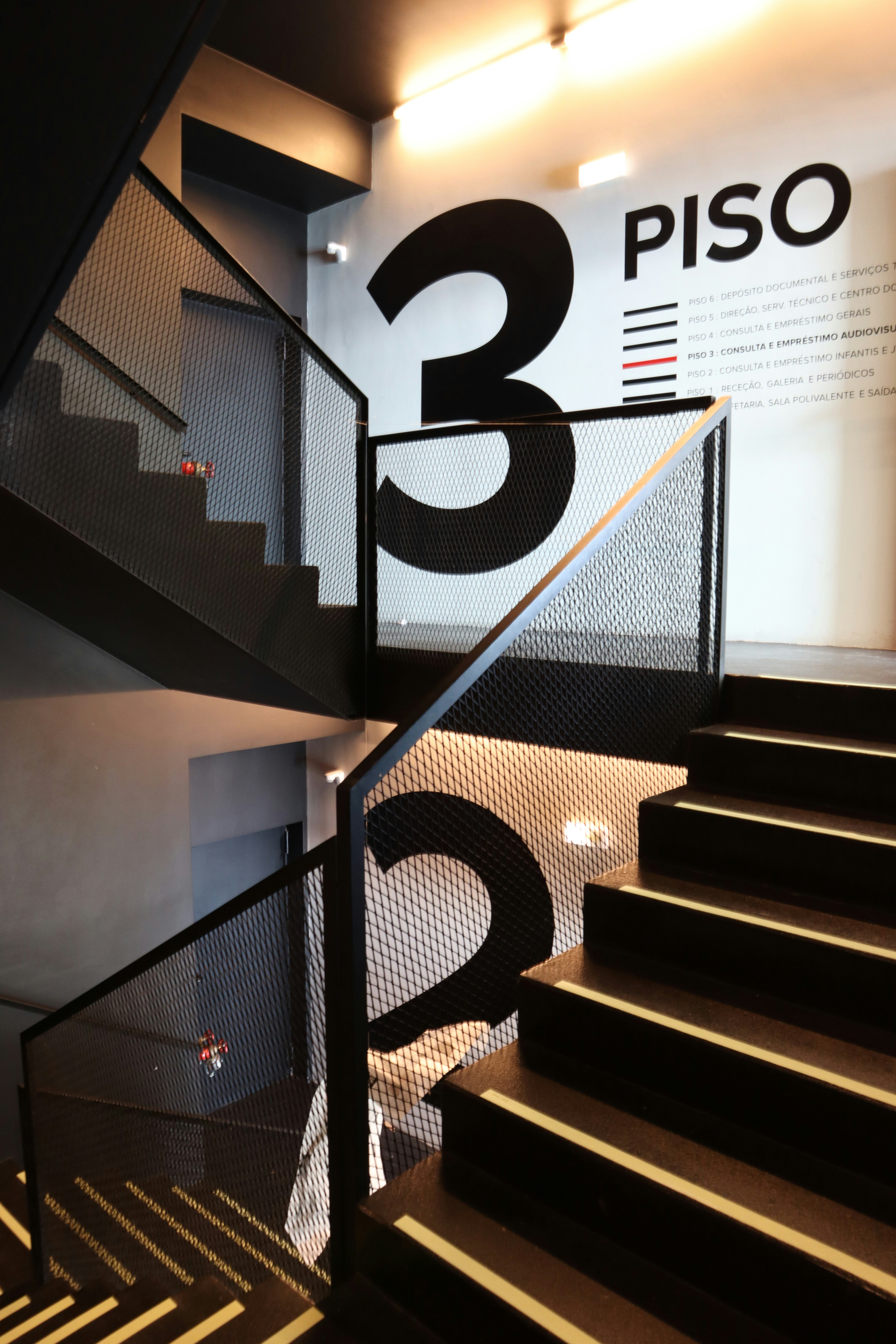 A staircase with a sign on the wall next to it