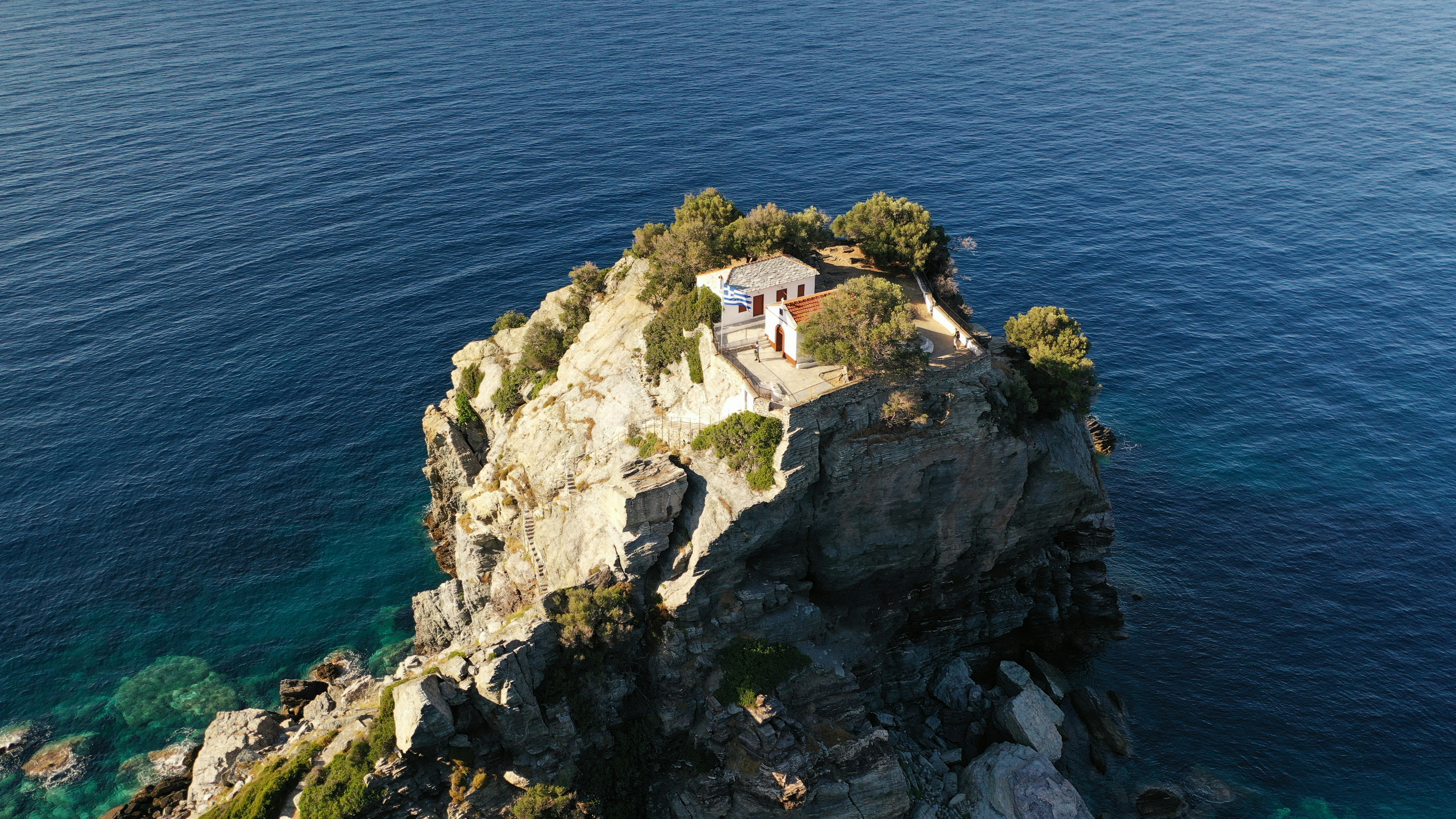 A house on a rock in the middle of the ocean, An aerial view of Mamma Mia church in Skopelos island, Greece.