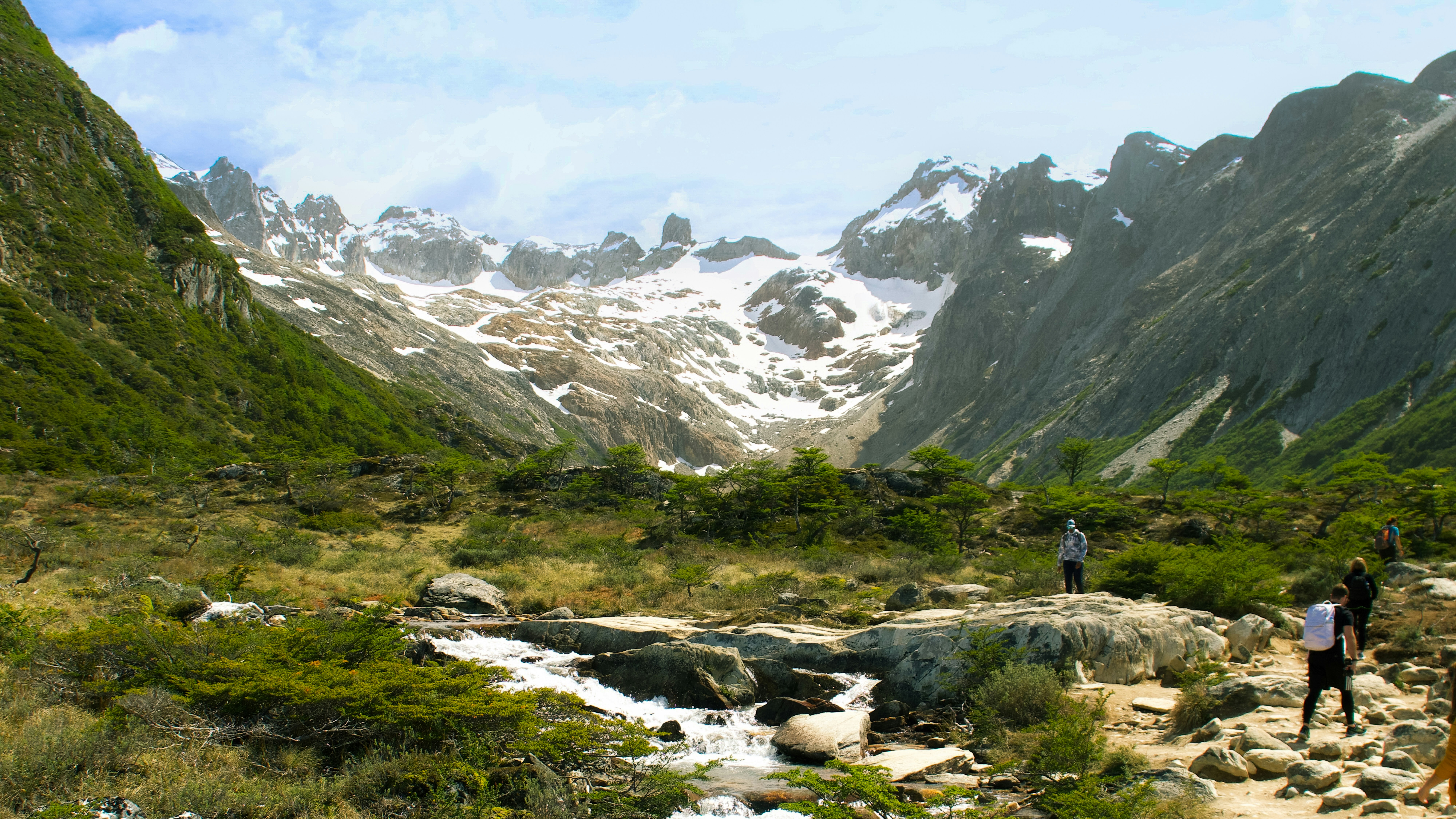 A couple of people walking down a dirt road