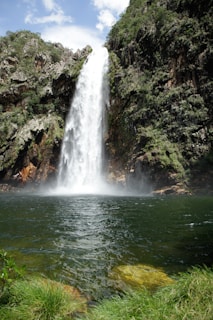 A large waterfall is in the middle of a body of water