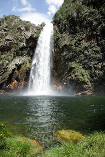 A large waterfall is in the middle of a body of water