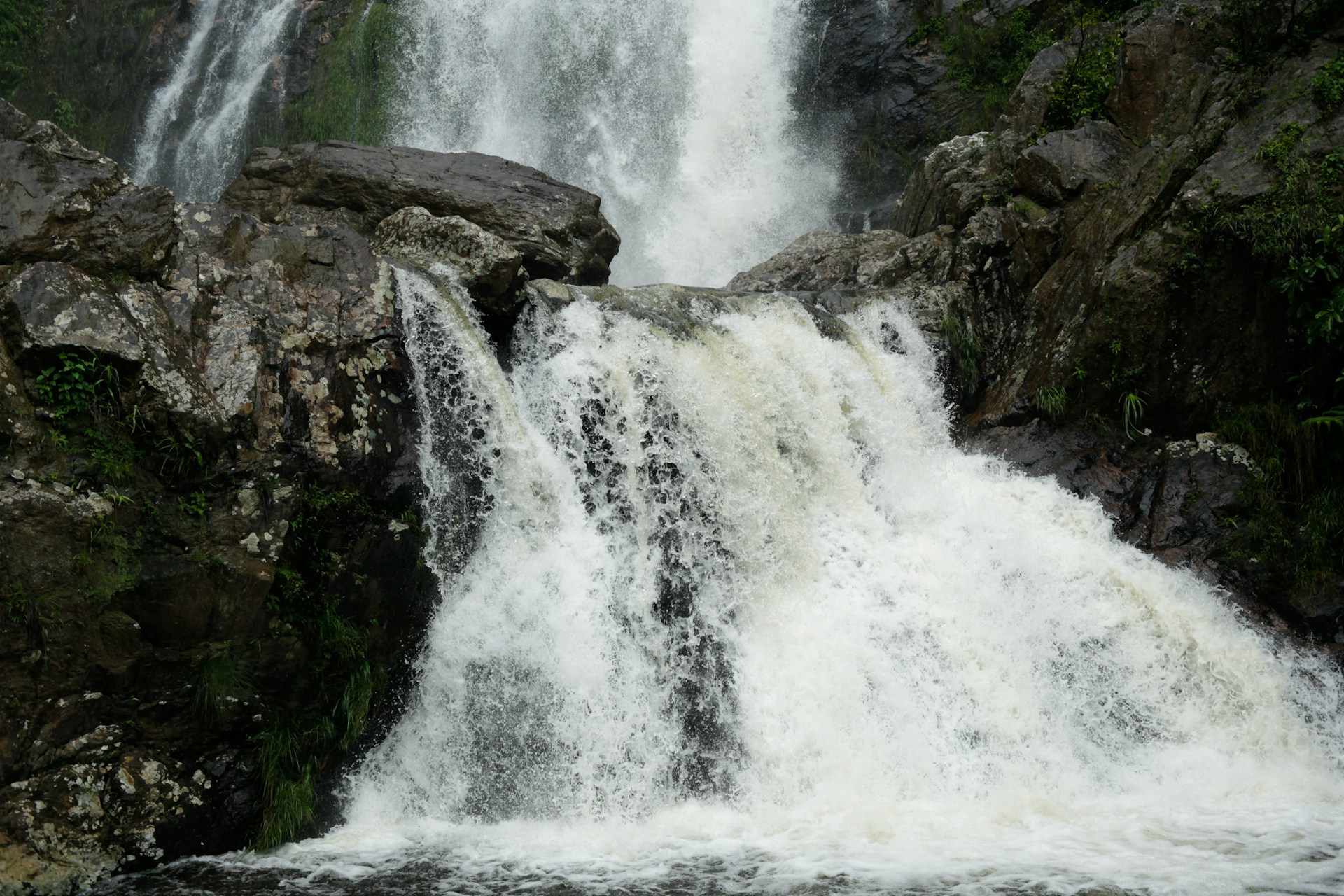 A large waterfall with a man swimming in it