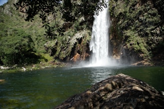 A large waterfall is in the middle of a body of water