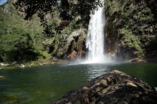 A large waterfall is in the middle of a body of water