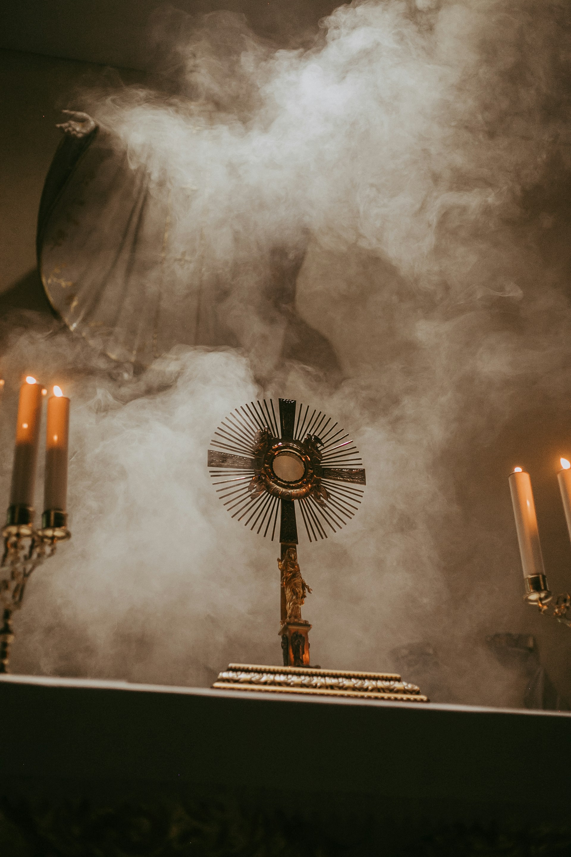 A cross on a table surrounded by candles