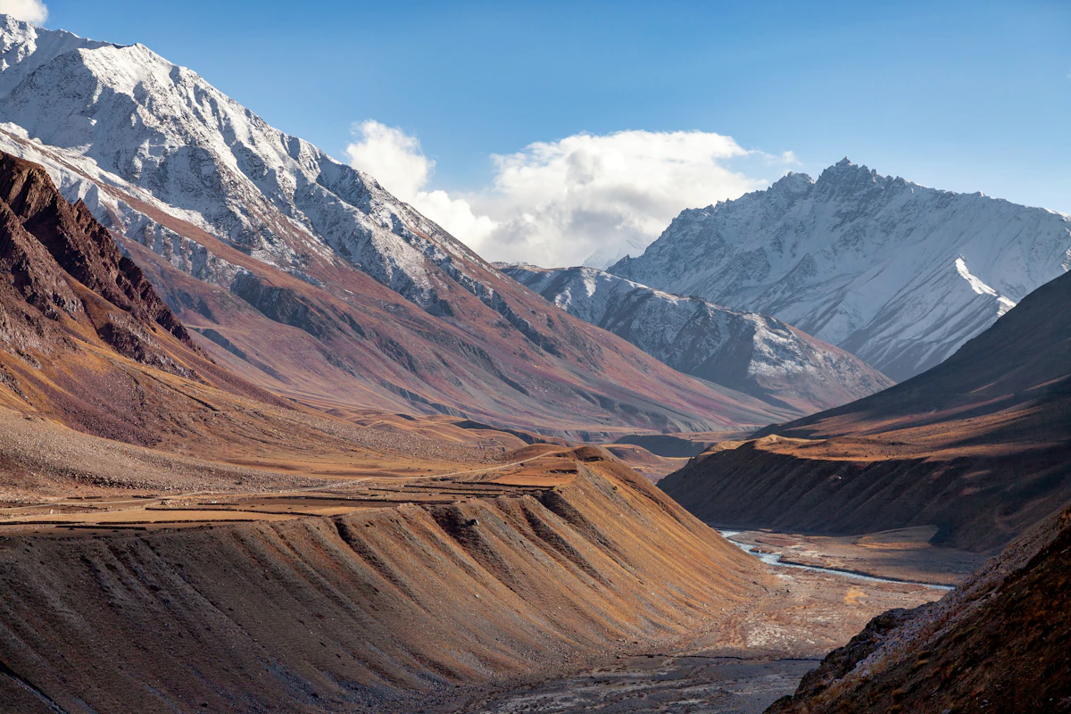 A mountain range with a river running through a rocky valley