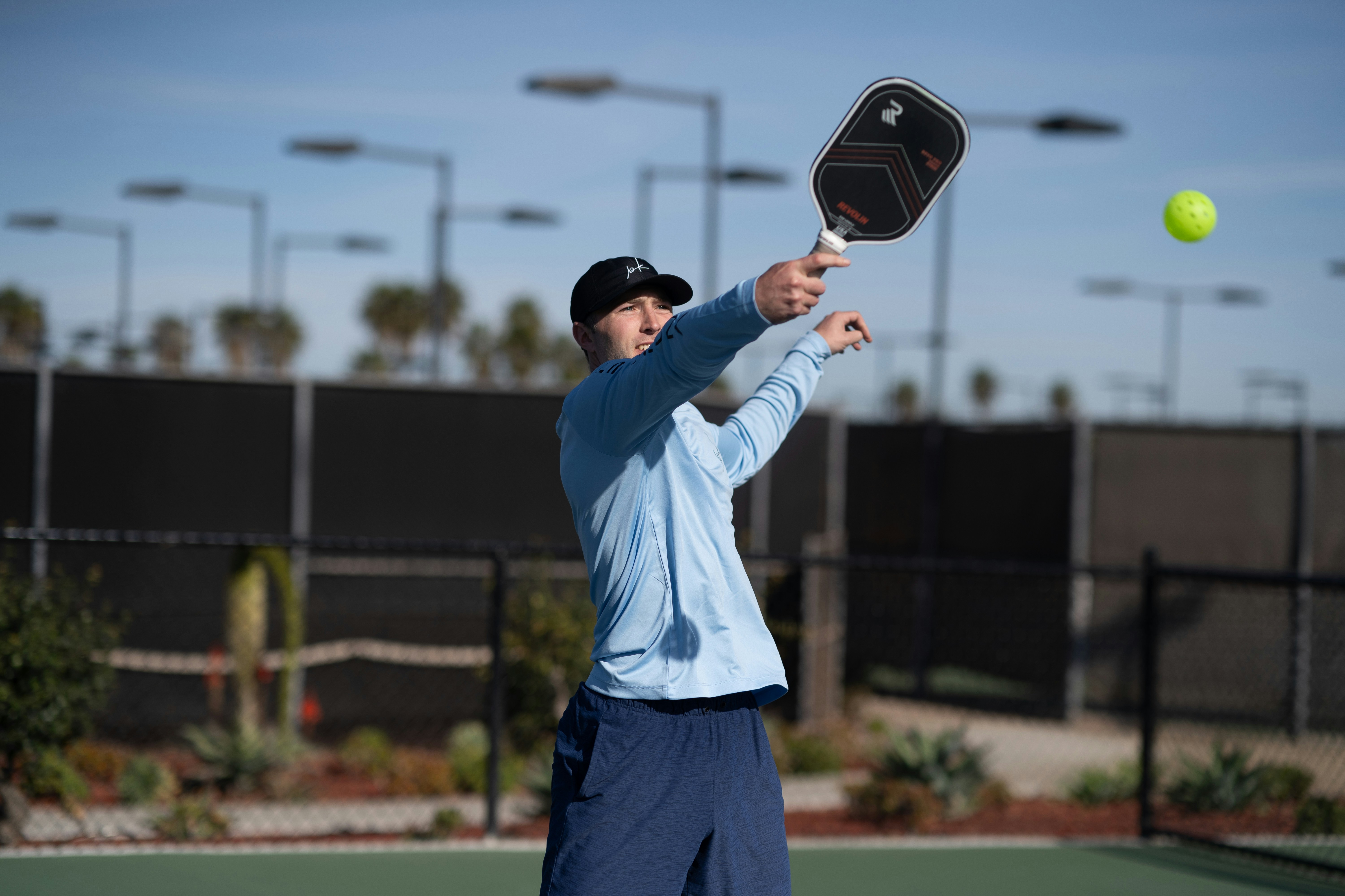 A man holding a tennis racquet on top of a tennis court