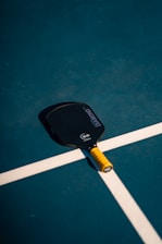 A tennis racket and ball on a tennis court