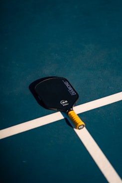 A tennis racket and ball on a tennis court