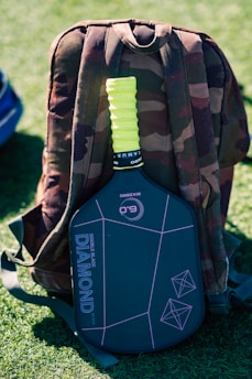 A back pack sitting on top of a green field