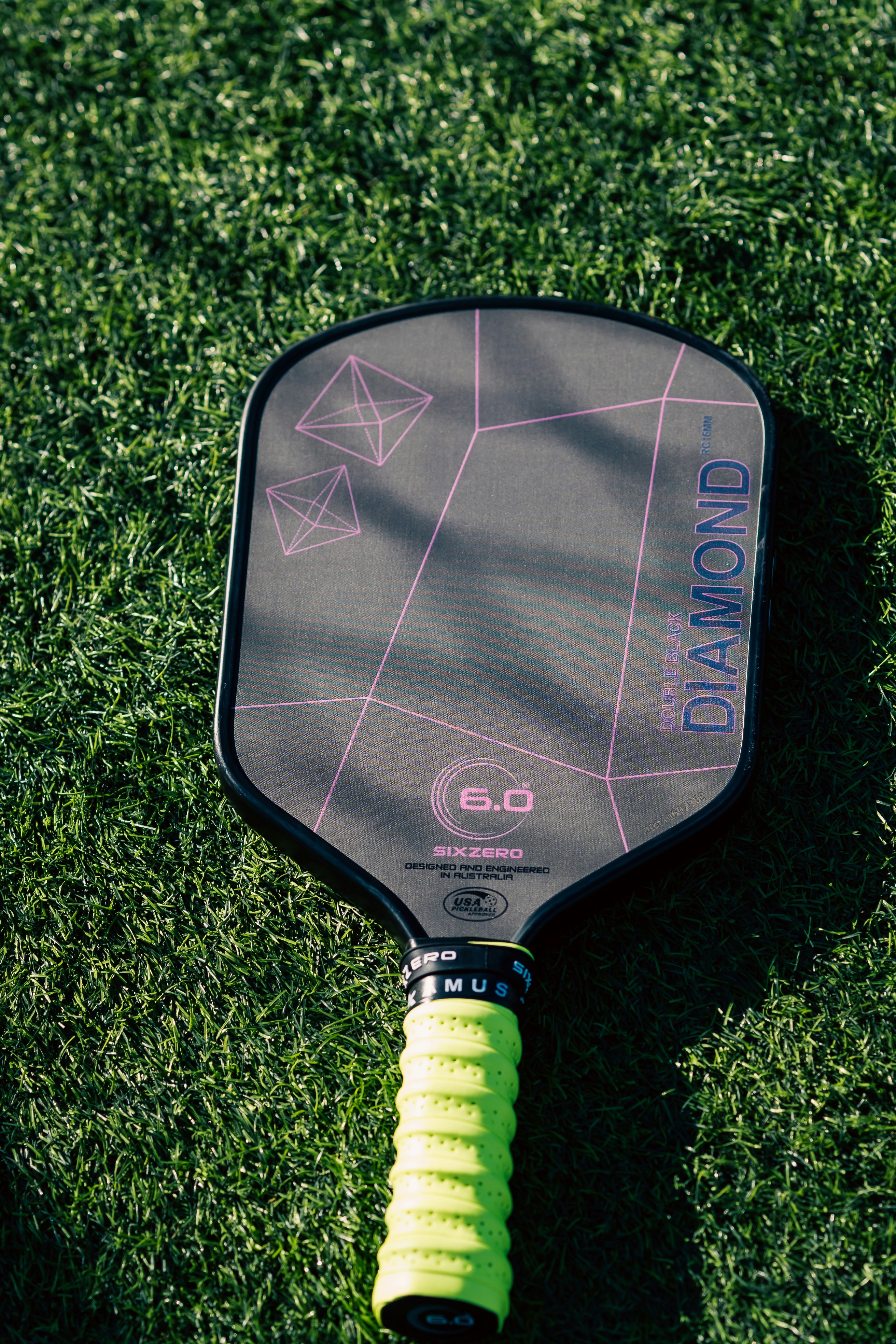 A close up of a tennis racket on the grass