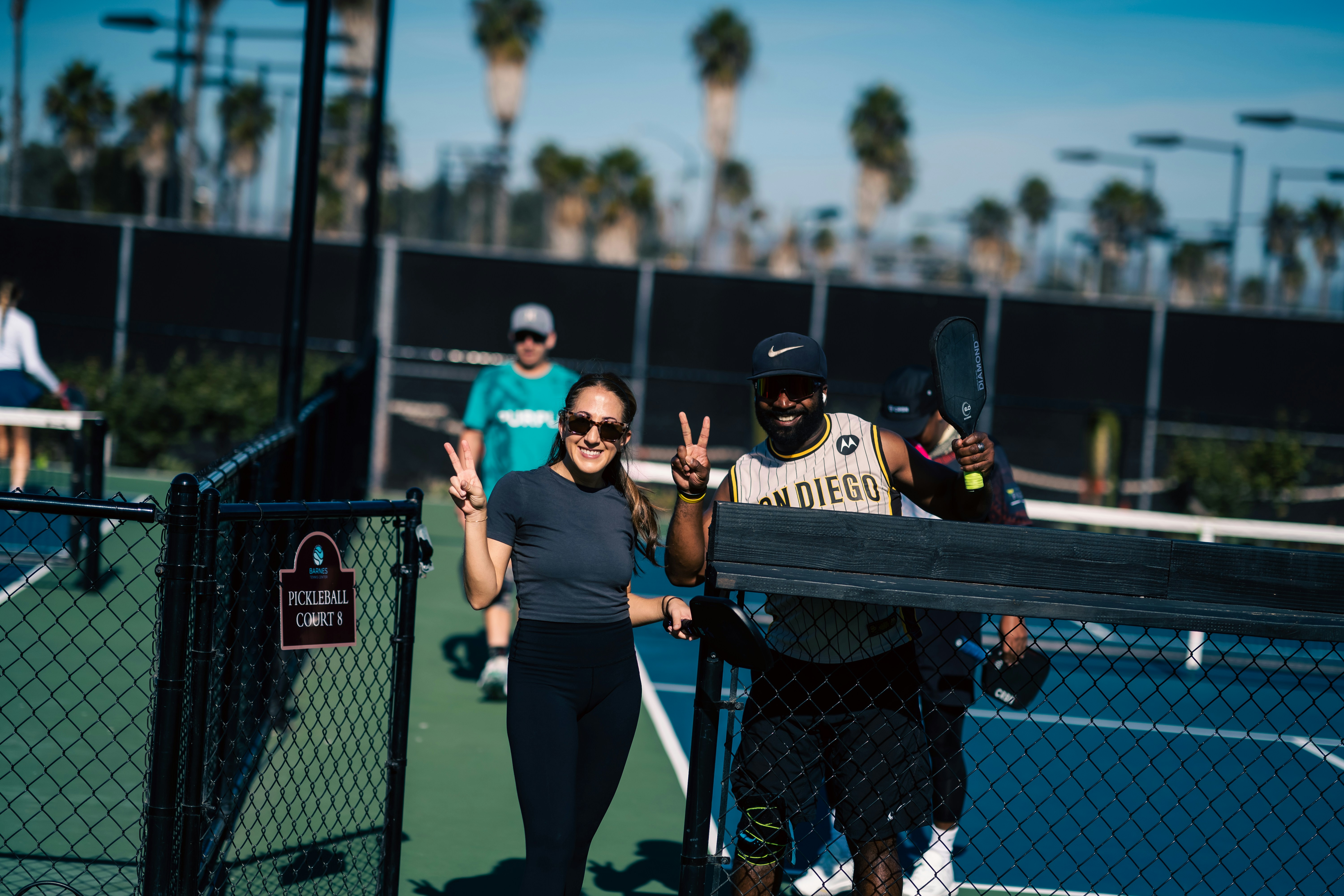 A group of people standing on top of a tennis court
