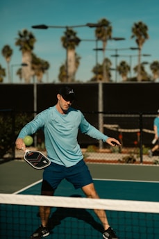 A man holding a tennis racquet on top of a tennis court