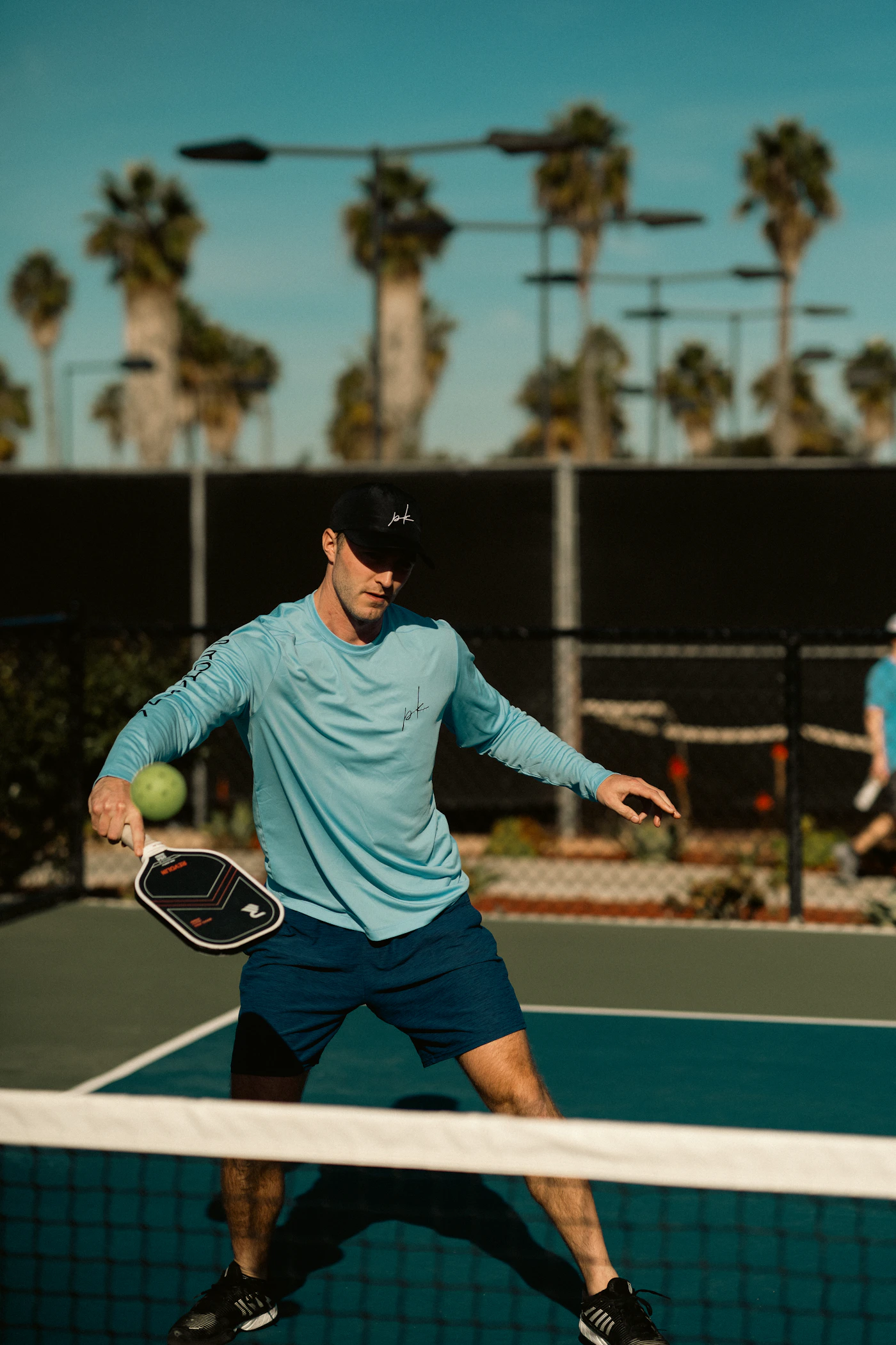 Pickleball player moving at the kitchen line during an outdoor game.