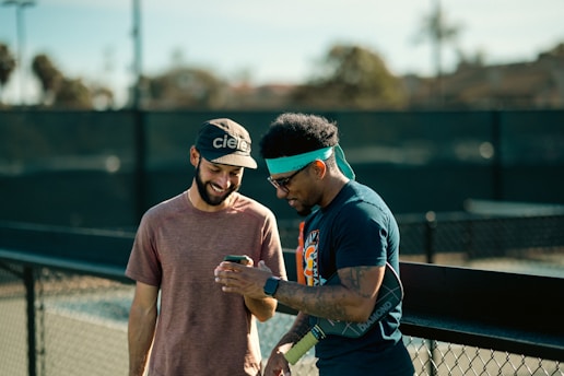 A couple of men standing on top of a tennis court