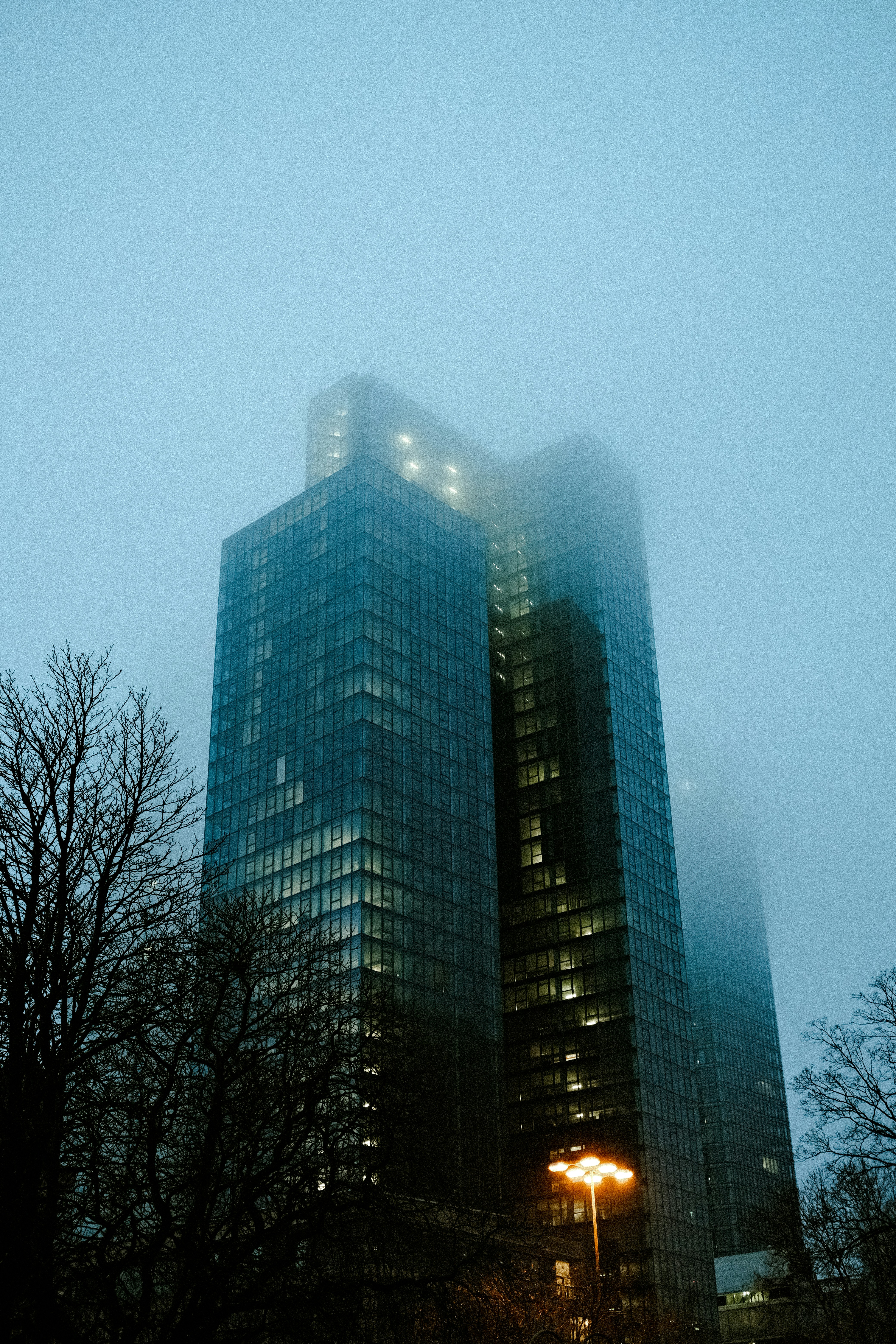 A very tall building in the middle of a foggy night