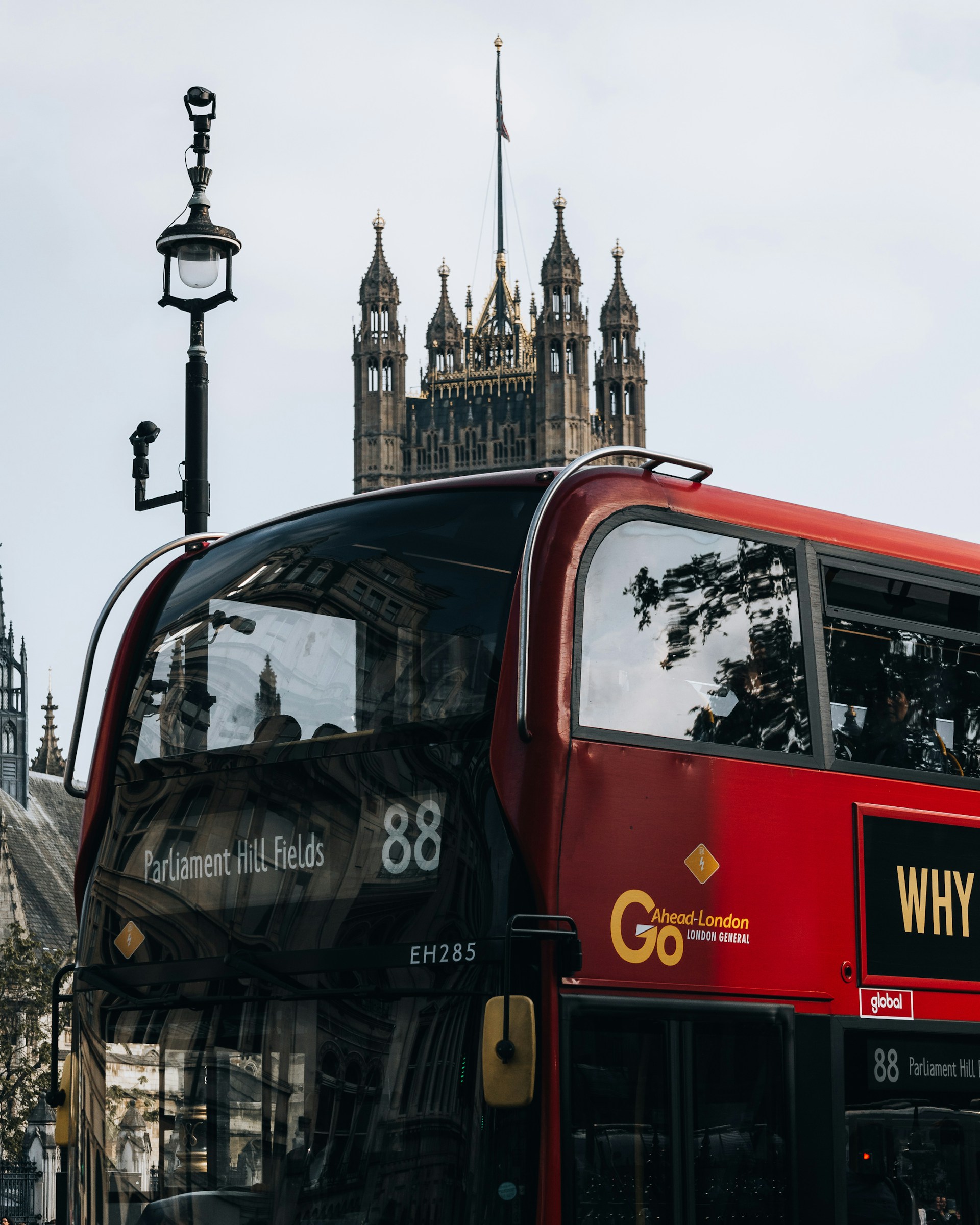 A red double decker bus driving down a street