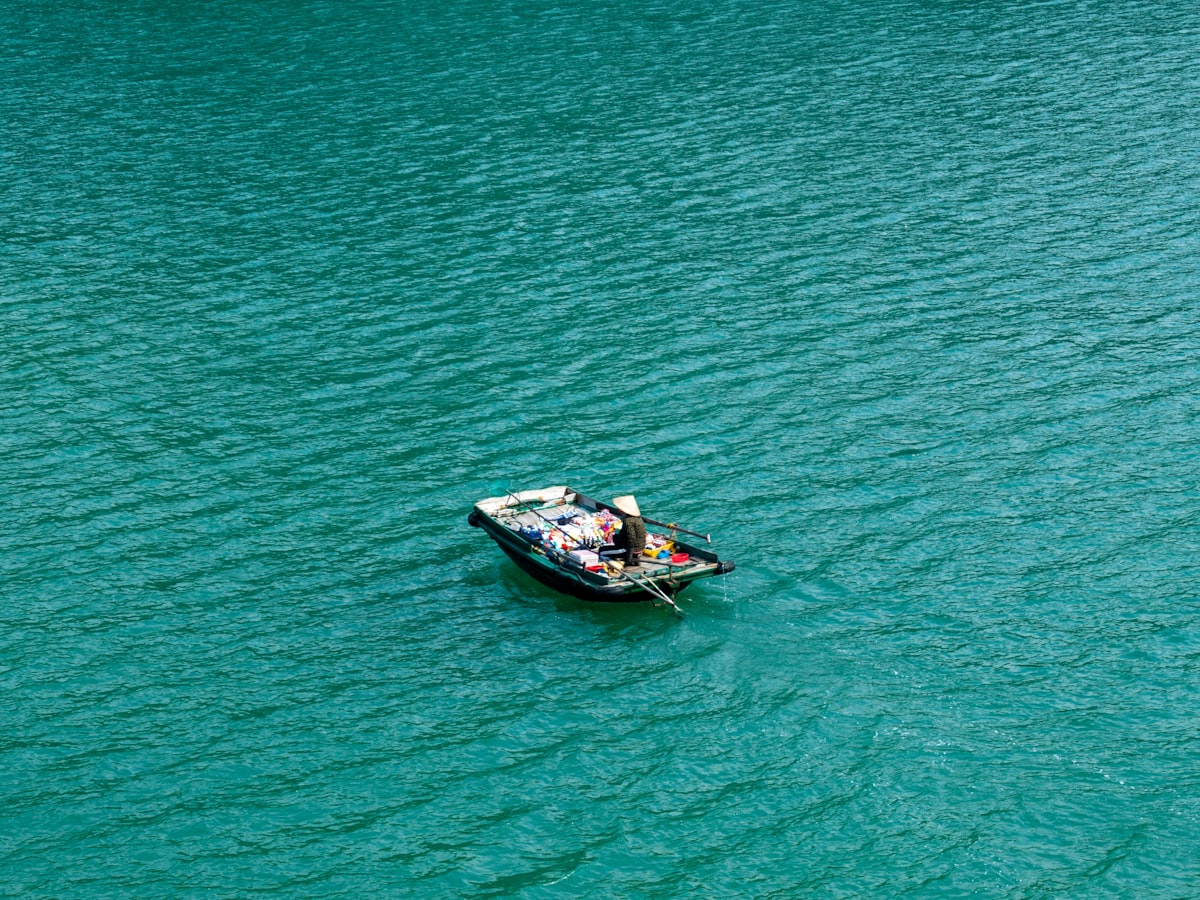 A small boat floating on top of a large body of water